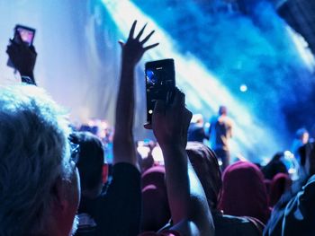 Man photographing performance at music concert