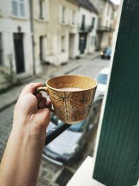 Close-up of hand holding coffee cup