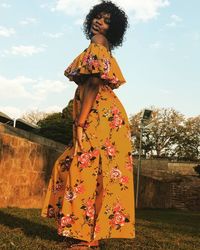 Woman standing by tree against sky
