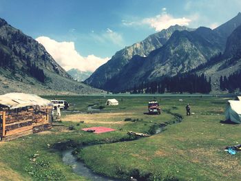 Scenic view of field and mountains against sky