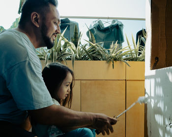 Father and child painting cardboard together. diy project at home.