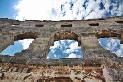 Low angle view of old building against cloudy sky