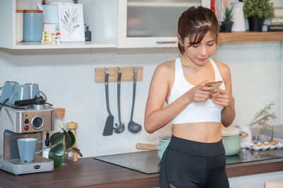 Young woman using mobile phone at home