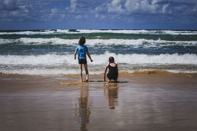 Rear view of siblings at beach