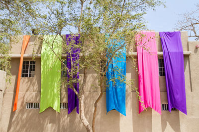 Low angle view of colorful fabric drying on building
