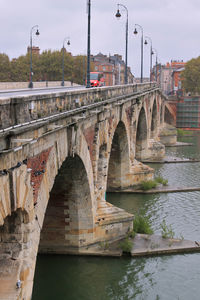 Arch bridge over river against sky