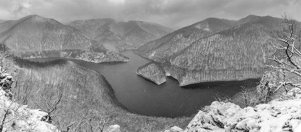 Scenic view of river amidst mountains against sky