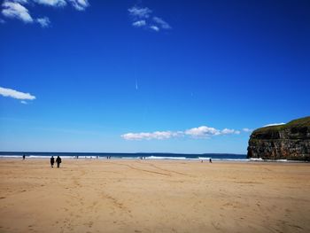 Scenic view of beach against blue sky