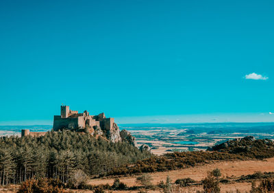 Buildings by sea against blue sky