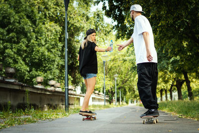 Couple with skateboards on footpath at park