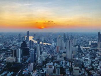 Aerial view of modern buildings against sky during sunset