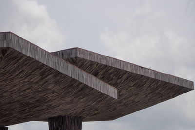 Low angle view of text on roof against sky