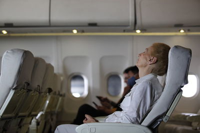 Rear view of man sitting in airplane