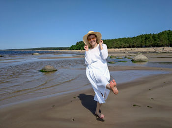 Full length of young woman standing on beach