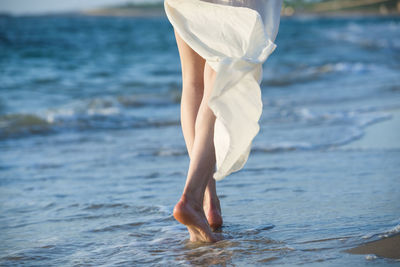 Low section of woman standing on beach