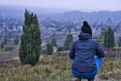 Rear view of man looking at trees