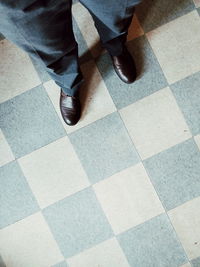 Low section of man standing on tiled floor