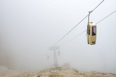 Overhead cable car against sky during winter