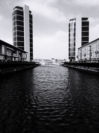 Buildings in city against cloudy sky