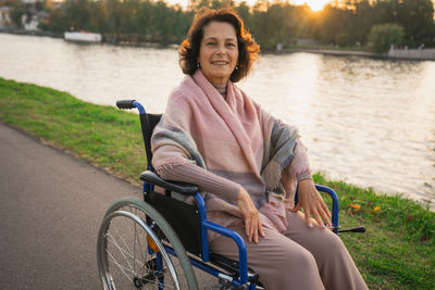 Portrait of smiling young woman sitting on wheelchair