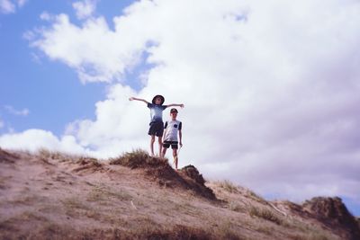 Low angle view of boys on street against sky