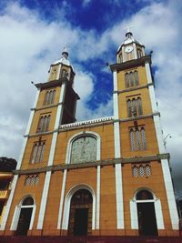 Low angle view of building against cloudy sky