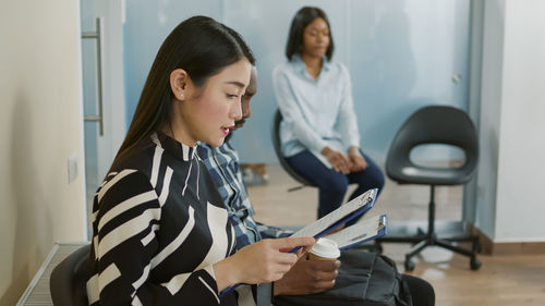 Side view of woman reading form