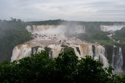 Scenic view of waterfall against sky