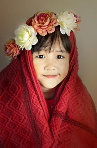 Portrait of smiling girl with red flower