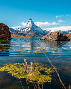 Scenic view of lake and mountains against blue sky