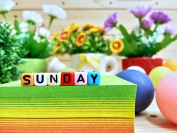 Close-up of colorful blocks with sunday text on stacked papers over table