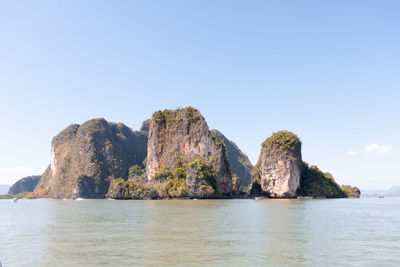 Rock formation in sea against sky