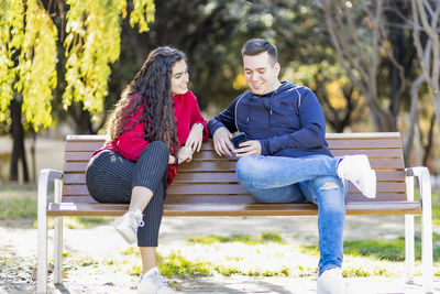 Smiling teenage friends sitting on seat