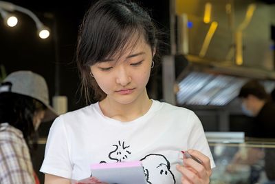 Close-up of woman reading note pad