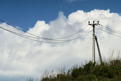 Low angle view of electricity pylon against sky