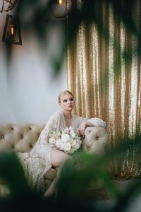 Young woman sitting on sofa at home