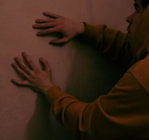 Close-up of hands on table against wall