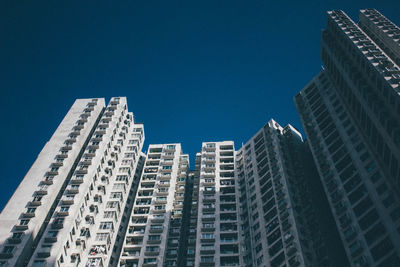 Low angle view of skyscrapers against blue sky