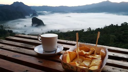 Breakfast on table by mountains against sky