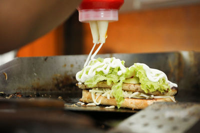 Cropped image of person making sandwich