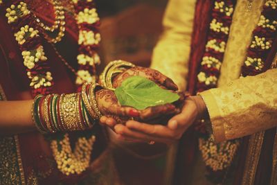 Midsection of bride and groom performing rituals