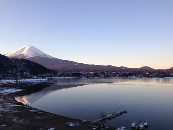 Scenic view of lake by mountains against clear sky