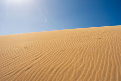 Sand dune in desert against clear sky