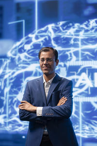 Portrait of businessman standing against sky at night
