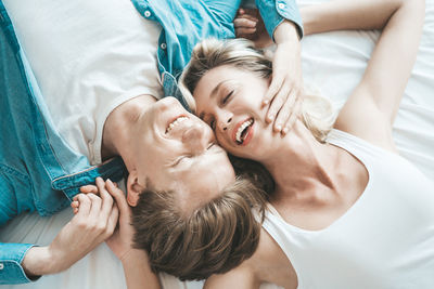 High angle view of friends lying on bed