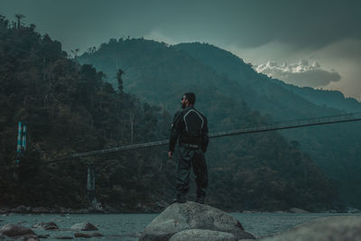 Man standing on mountain against sky