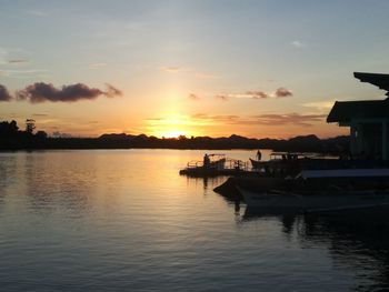 Silhouette boats in lake against sky during sunset