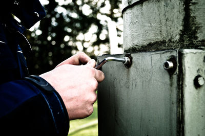 Close-up of hands holding metallic handle