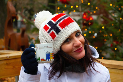 Portrait of woman with hat on christmas tree