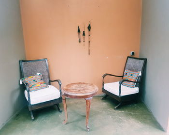 Empty chairs and table against wall at home